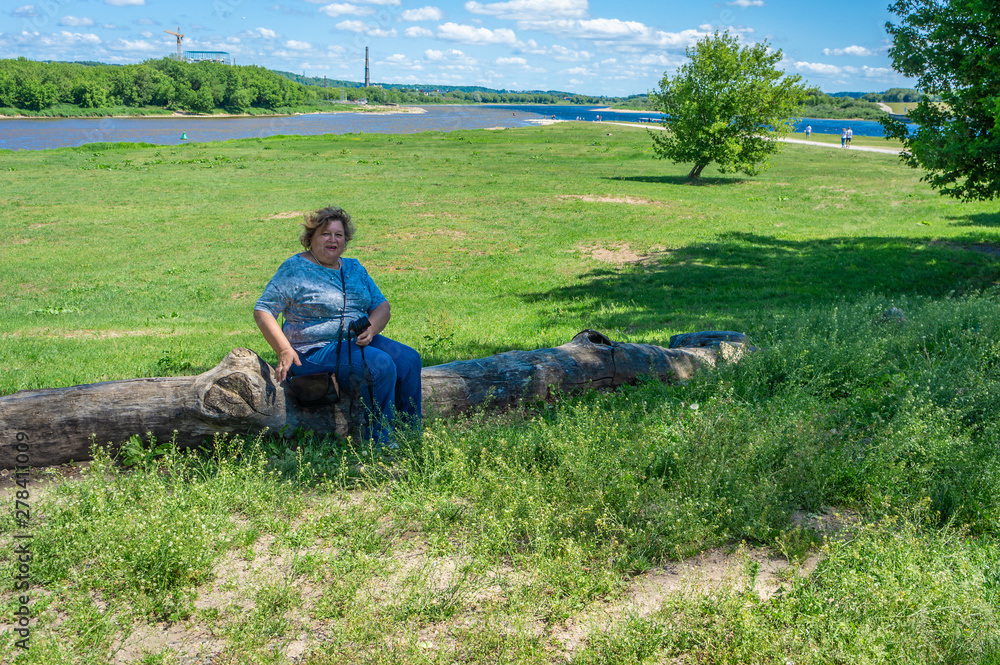 Mature woman tourist sitting on a log Mature woman tourist sitting on a log