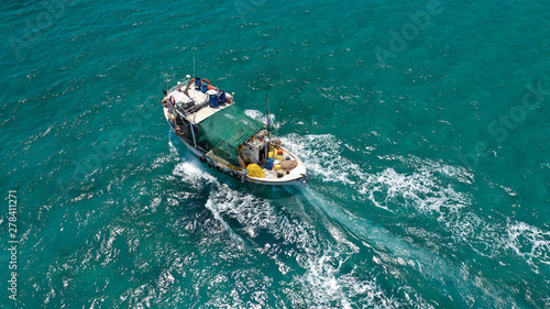 Aerial top view photo of big traditional fishing boat cruising in emerald sea near port of Paros island, Cyclades, Greece © aerial-drone