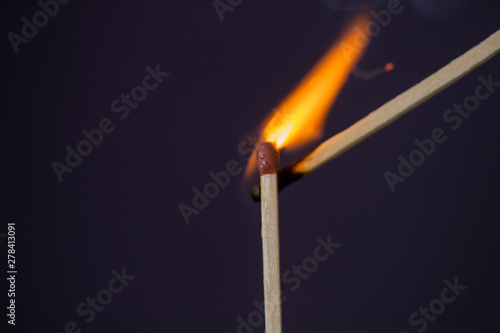 Close up Macro shot of a ignition match on a second match captured in super slow motion