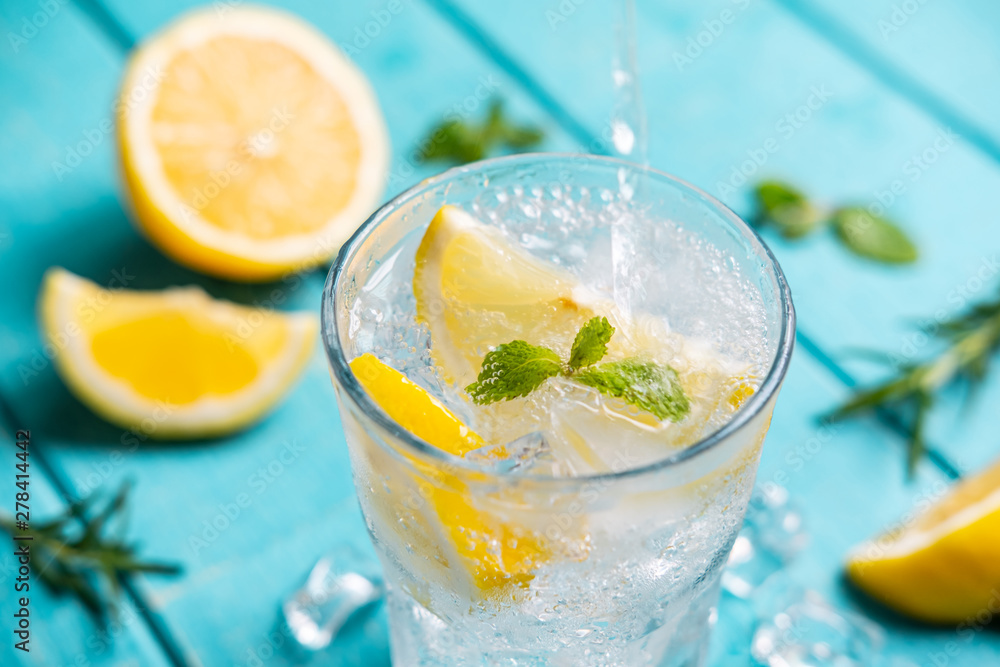 Refreshing lemonade in glass with lemon on wooden table - obrazy, fototapety, plakaty 