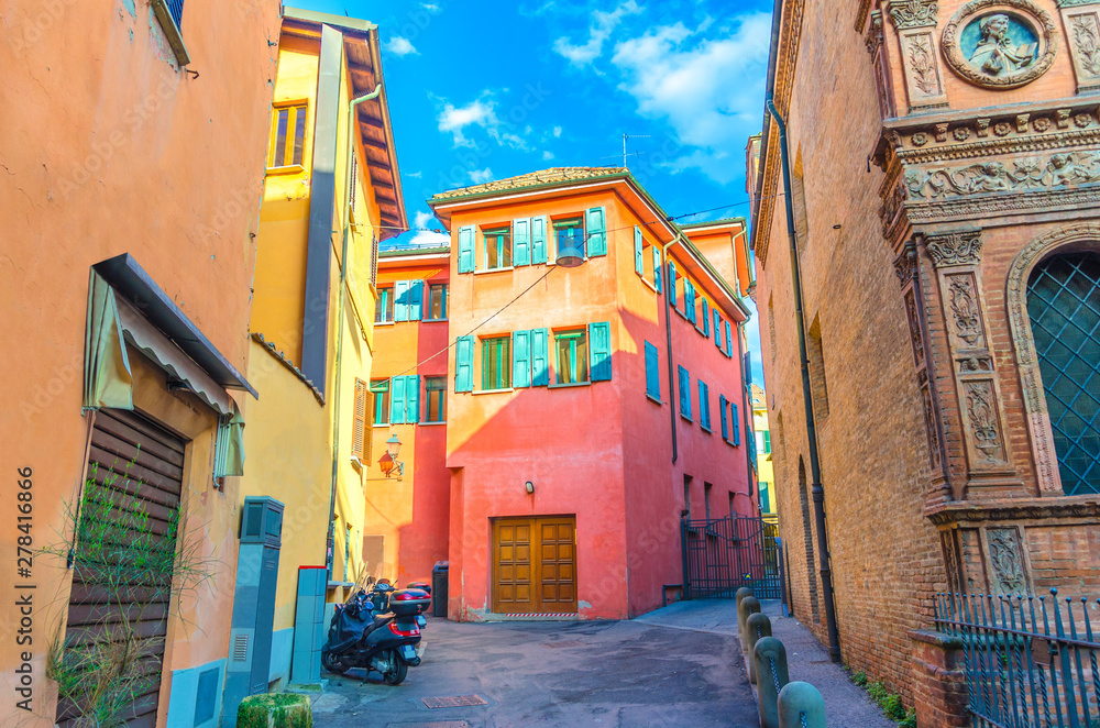 Typical italian yard, traditional buildings with colorful bright walls and bikes on the street in old historical city centre of Bologna, Emilia-Romagna, Italy