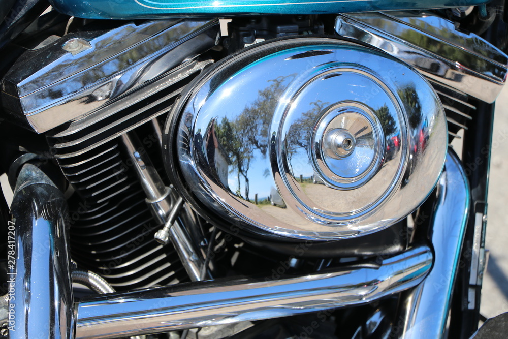 Polished chrome elements of a motorbike engine with reflection, as closeup