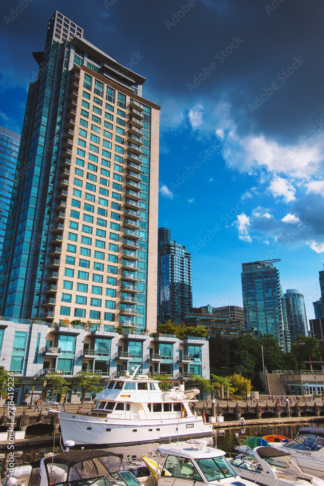 Obraz premium Whytecliff Park in Greater Vancouver British Columbia Canada in the Pacific North West featuring still calm waters of the ocean and a path of rocks leading to an island. Featuring cityscapes.