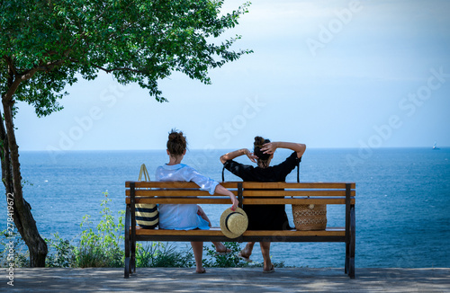 .girls on a bench against the sea