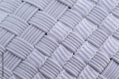 Fragment of a white cloth sneaker. The texture of the material of sports shoes