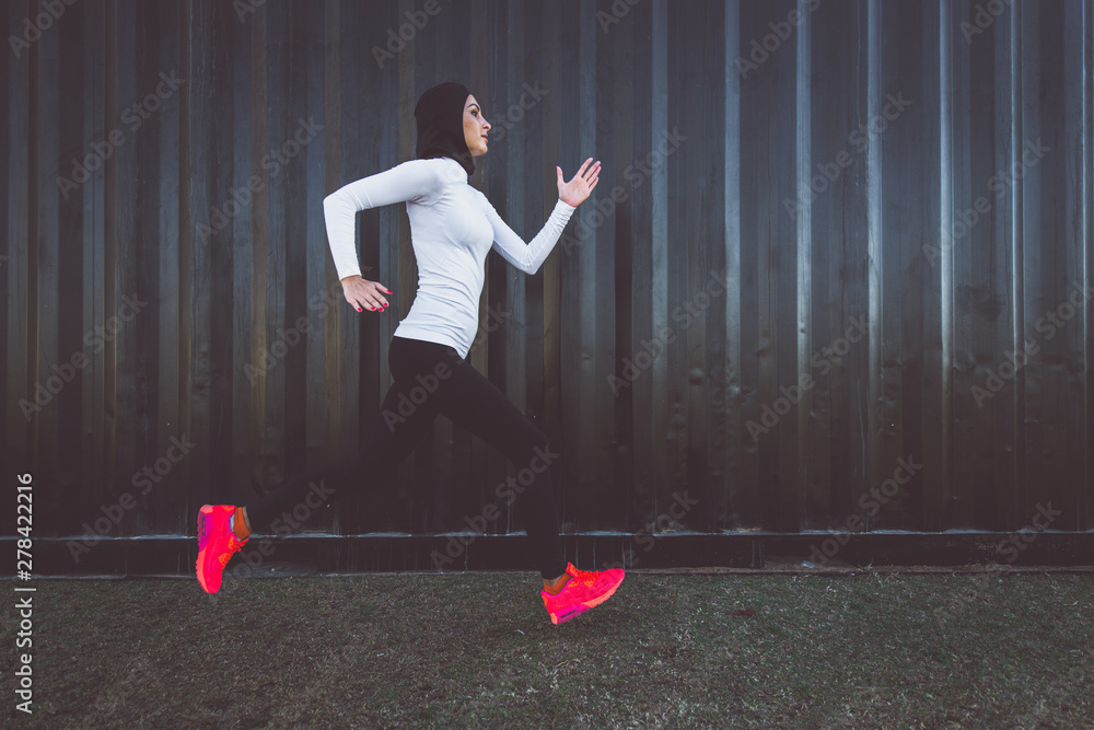 Arabic woman runner, making some urban running - obrazy, fototapety, plakaty 