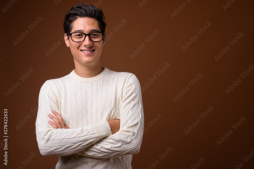 Young multi-ethnic handsome man against brown background Young multi-ethnic handsome man against brown background