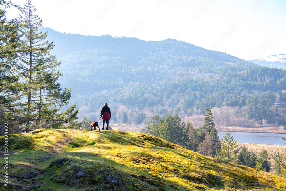 Obraz premium Man and dog hiking on Vancouver Island, BC, Canada