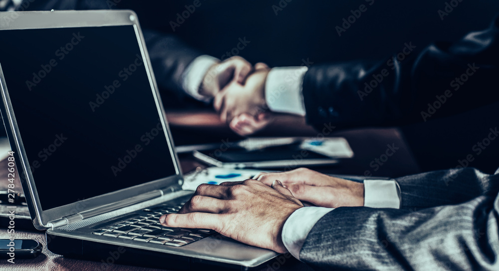 closeup of businessman working on laptop on background of busine closeup of businessman working on laptop on background of busine