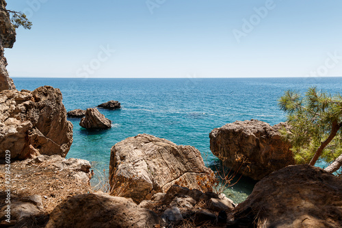 Beautiful seascape. Seascape on the background of the wild rocky coast. Wild beach, azure water and rocks. Luxury summer adventure, Mediterranean sea, Turkey. Postcard view
