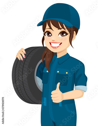 Female mechanic holding tire wheel making positive thumb up