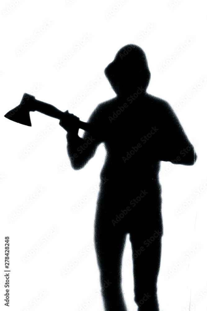 Dangerous man behind frosted glass with an axe in his hand. Halloween. Black and white image. Dangerous man behind frosted glass with an axe in his hand. Halloween. Black and white image.
