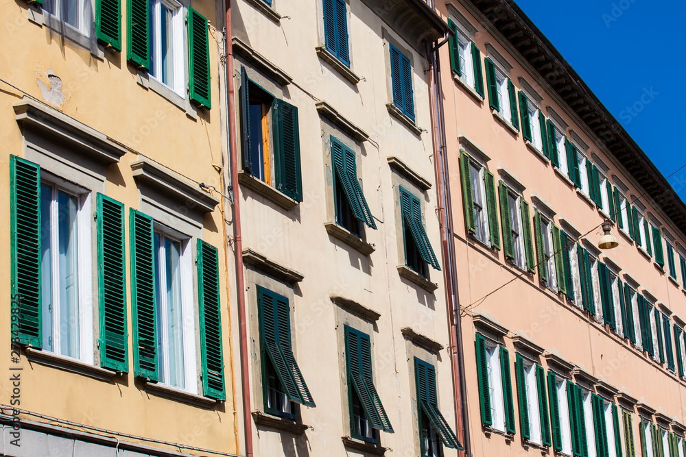 Colorful buildings with many wooden windows at Pisa city center