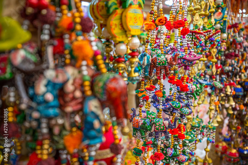 Colourful traditional handmade Indian decorative beads and crafted animal decorations and souvenirs hang outside a market stall in the Little India area of Singapore, Asia