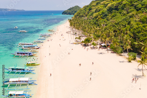 Puka Shell Beach, Boracay Island, Philippines, aerial view. Tropical white sand beach and beautiful lagoon. Tourist boats and people on the beach. People relax on the beautiful coast.