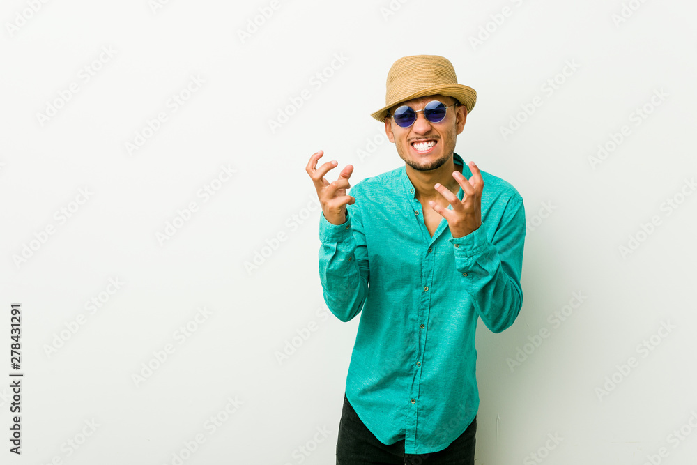 Young hispanic man wearing a summer clothes upset screaming with tense hands.