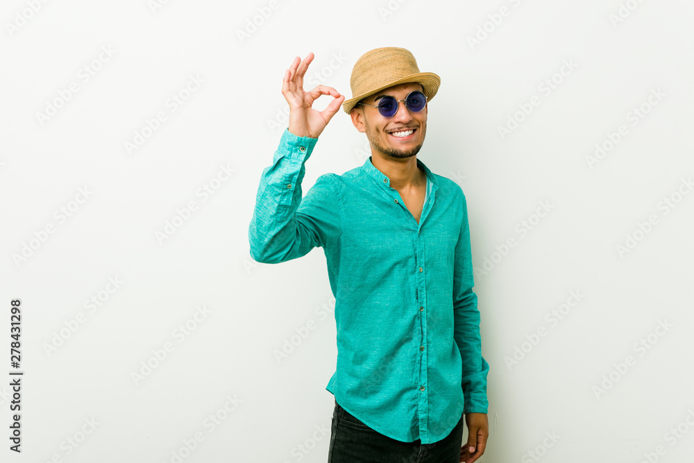 Young hispanic man wearing a summer clothes cheerful and confident showing ok gesture. Young hispanic man wearing a summer clothes cheerful and confident showing ok gesture.