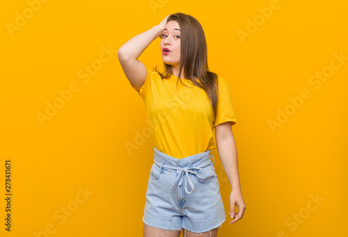 Young woman teenager wearing a yellow shirt tired and very sleepy keeping hand on head.