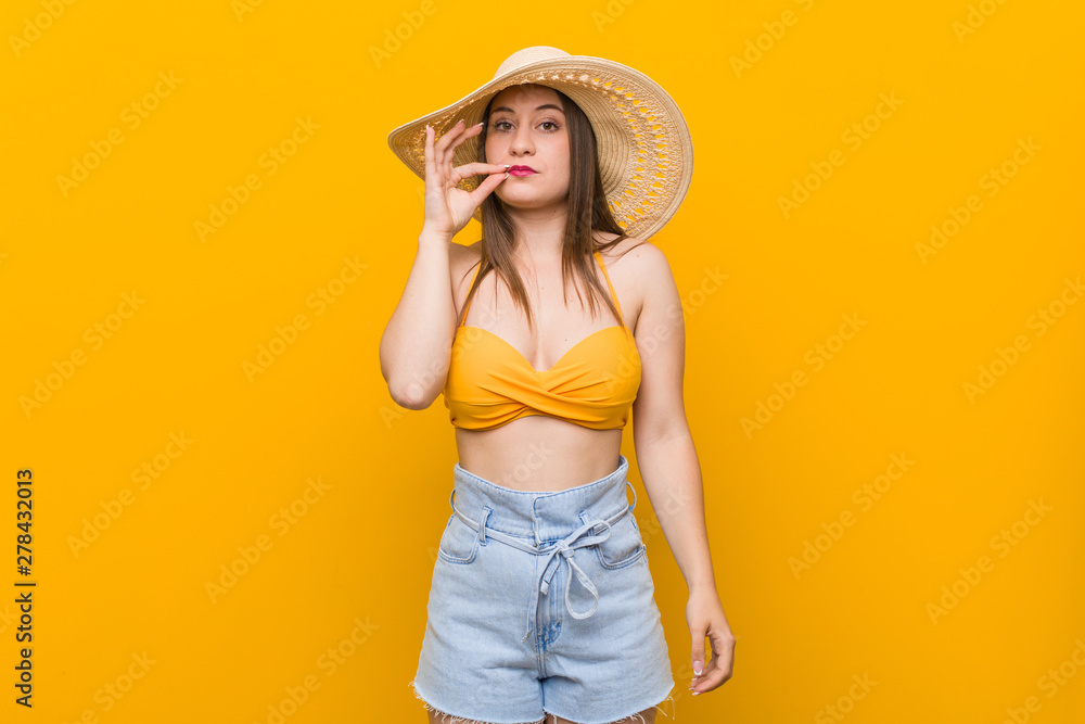 Young caucasian woman wearing a straw hat, summer look with fingers on lips keeping a secret. Young caucasian woman wearing a straw hat, summer look with fingers on lips keeping a secret.