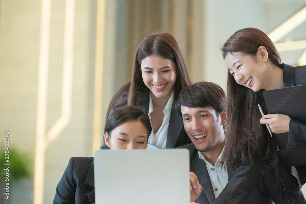Young Asian business people are meeting in office . Group of Business team working Meeting at the screen monitor Young Asian business people are meeting in office . Group of Business team working Meeting at the screen monitor