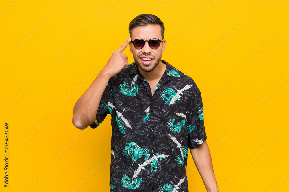 Young filipino man wearing summer clothes showing a disappointment gesture with forefinger. Young filipino man wearing summer clothes showing a disappointment gesture with forefinger.