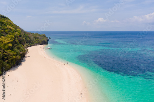Puka Shell Beach. Wide tropical beach with white sand. Beautiful white beach and azure water on Boracay island  Philippines  top view. Tourists relax on the beach.