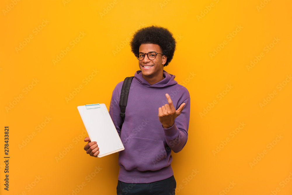 Young african american student man holding a clipboard inviting to come Young african american student man holding a clipboard inviting to come