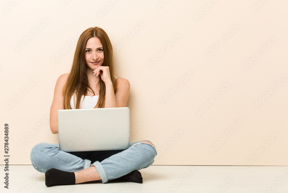 Young ginger woman sitting on her house floor smiling happy and ...