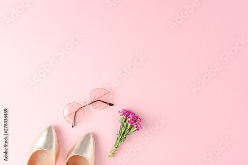 Fashion background with golden high heels, sunglasses and flowers