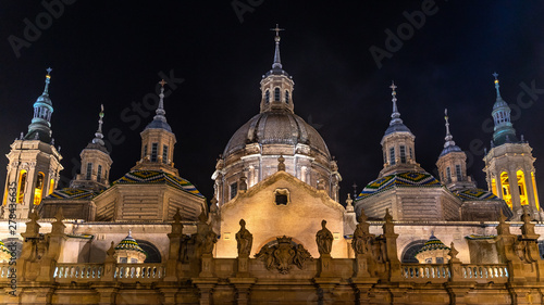 Scenic night view with illuminated cupolas and towers of the Cathedral of Our Lady of the Pillar in Zaragoza, Aragon, Spain