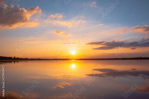 Sunset reflection lagoon. beautiful sunset behind the clouds and blue sky above the over lagoon landscape background. dramatic sky with cloud at sunset