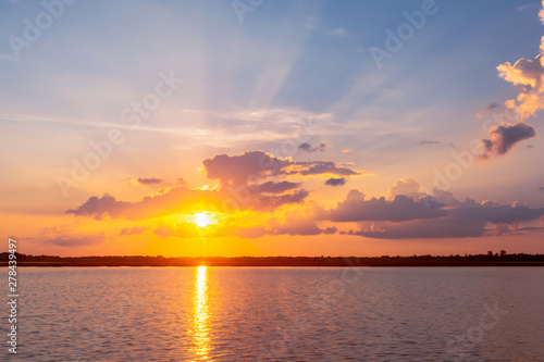 Sunset reflection lagoon. beautiful sunset behind the clouds and blue sky above the over lagoon landscape background. dramatic sky with cloud at sunset