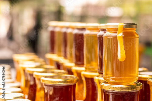 Pile of glass honey jars on the marketplace counter in Belgrade. Close up.