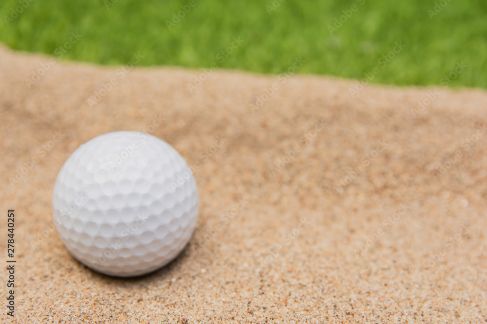 White golf ball in sand bunker on golf court. White golf ball in sand bunker on golf court.