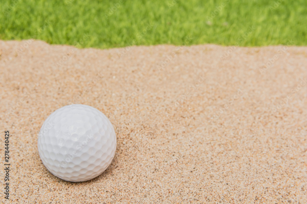 White golf ball in sand bunker on golf court. White golf ball in sand bunker on golf court.