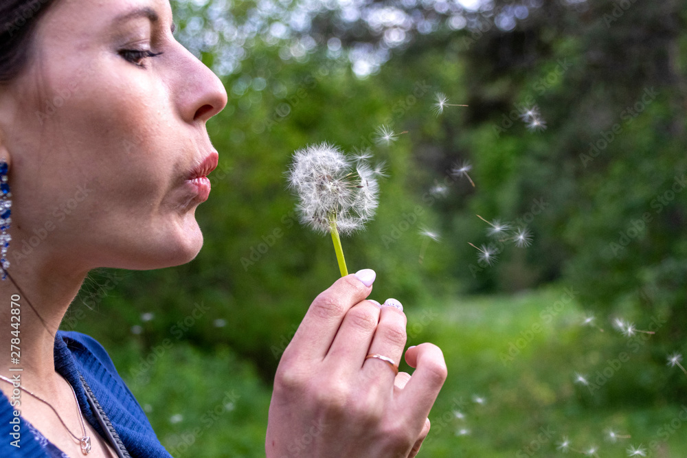 Happy beautiful woman blowing dandelion over sky background, having fun and playing outdoor, teen girl enjoying nature, summer vacation and holidays, young pretty female holding flower, wish concept Happy beautiful woman blowing dandelion over sky background, having fun and playing outdoor, teen girl enjoying nature, summer vacation and holidays, young pretty female holding flower, wish concept