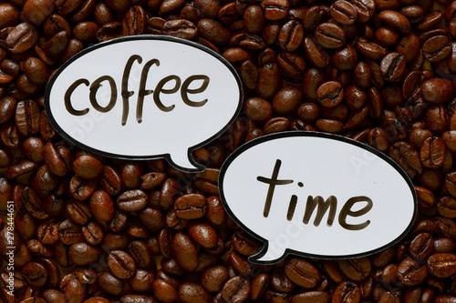 Coffee time text. White speech bubble on the background of coffee beans