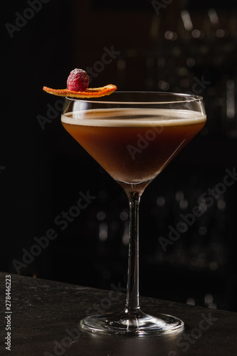 Espresso Martini Cocktail based on coffee, liqueur and vodka. Served with orange chips and raspberry. Space for text