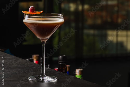 Espresso Martini Cocktail based on coffee, liqueur and vodka. Served with orange chips and raspberry. Space for text