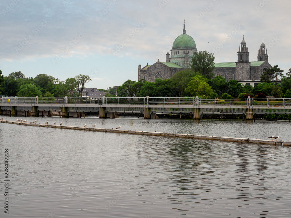 Galway cathedral, cloudy blue sky in the background. River Corrib, Summer day.
