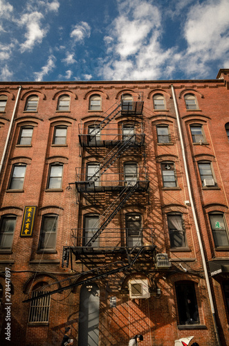 Old brick tenement houses with iron staircase in usa
