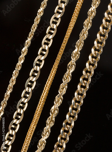 Five gold chain necklaces close up