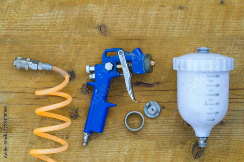 Parts of spray gun on a wooden table.