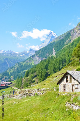 Traditional mountain hut in Swiss Alps close to picturesque Zermatt, Switzerland. Famous Matterhorn mountain in background. Alpine landscape in summer. Beautiful nature. Tourist destination