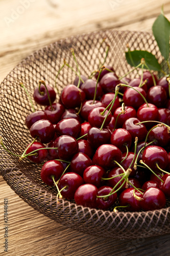 Fresh cherries on a fancy epergne on a wooden table, close up view photo