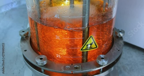 Growing bacteria in a bioreactor. Top view of a glass cylinder with a red one inside, which is mixed. Synthesis of new substances in the laboratory.