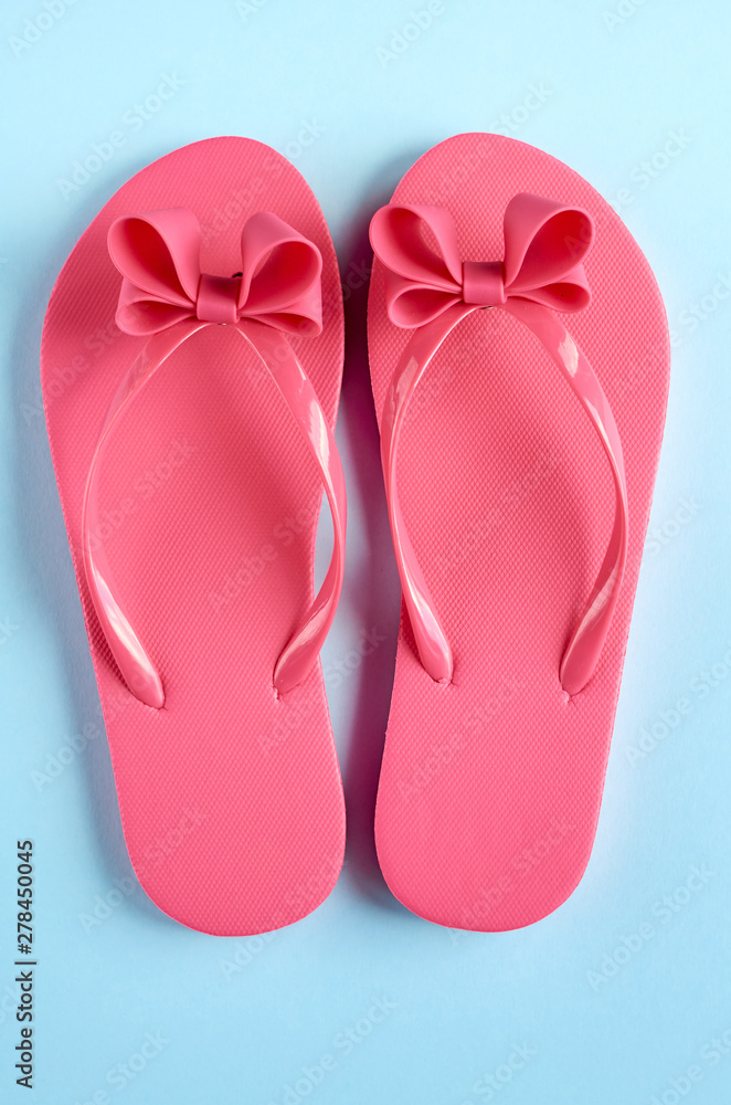 Pink rubber slippers on blue background composition. Pink rubber slippers on blue background composition.
