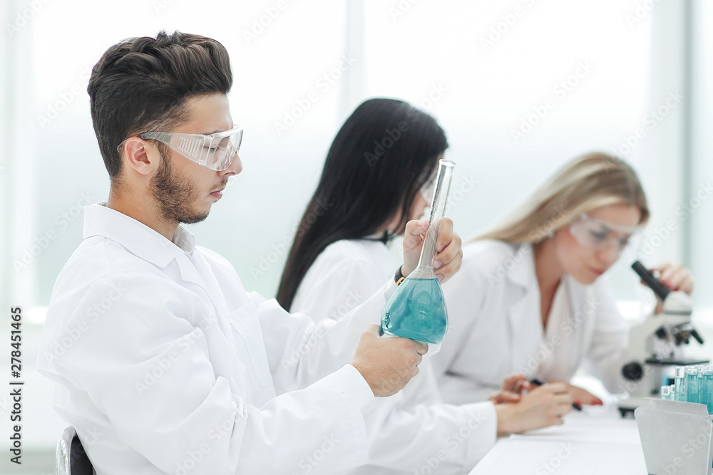group of scientists examines the liquid in the laboratory group of scientists examines the liquid in the laboratory