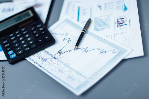 close up.pen, financial chart and calculator on the businessman's Desk