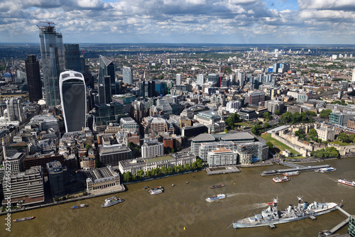 Fototapeta Naklejka Na Ścianę i Meble -  Aerial view of financial district skyscrapers on the muddy River Thames with Tower of London Castle and HMS Belfast warship London England